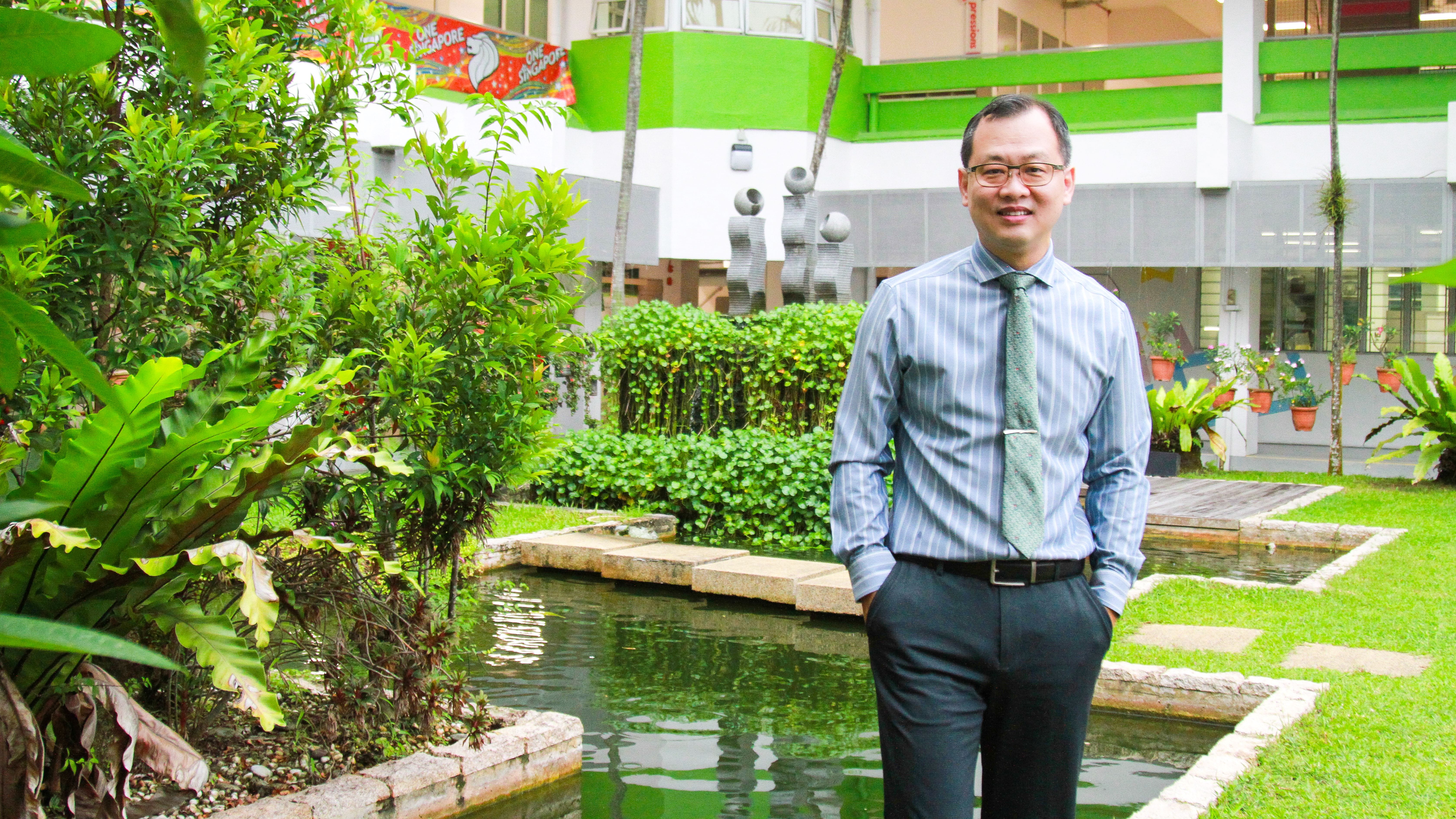 Photo of our school principal standing infront of our school pond.
